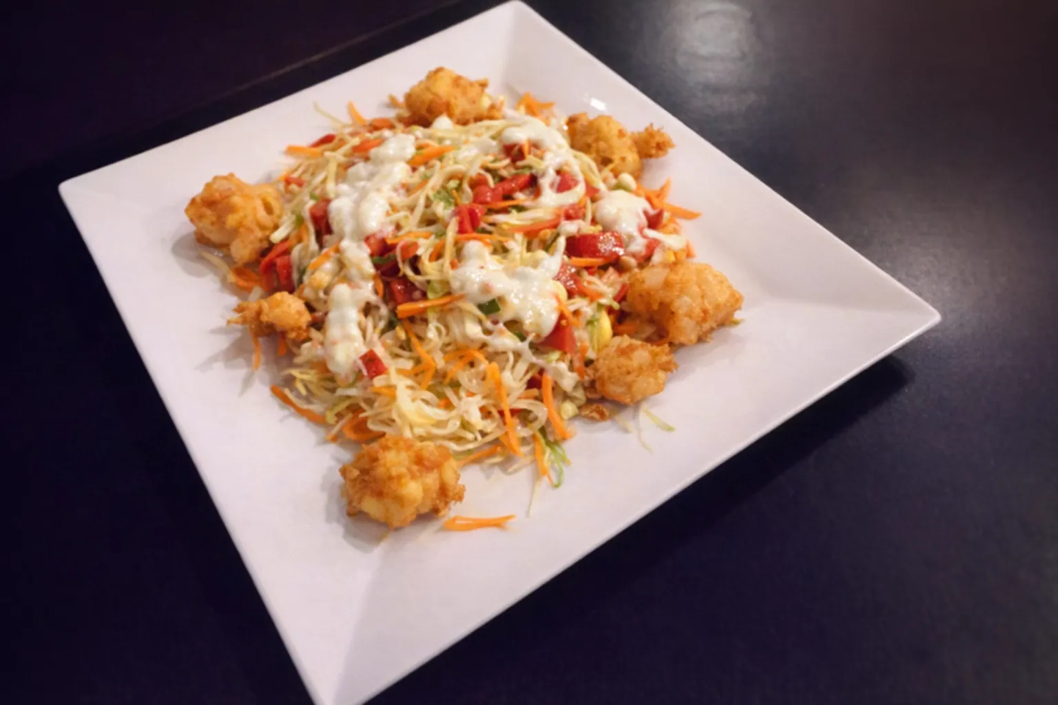 Plated dish with crispy toppings and fresh salad at Sea Breeze