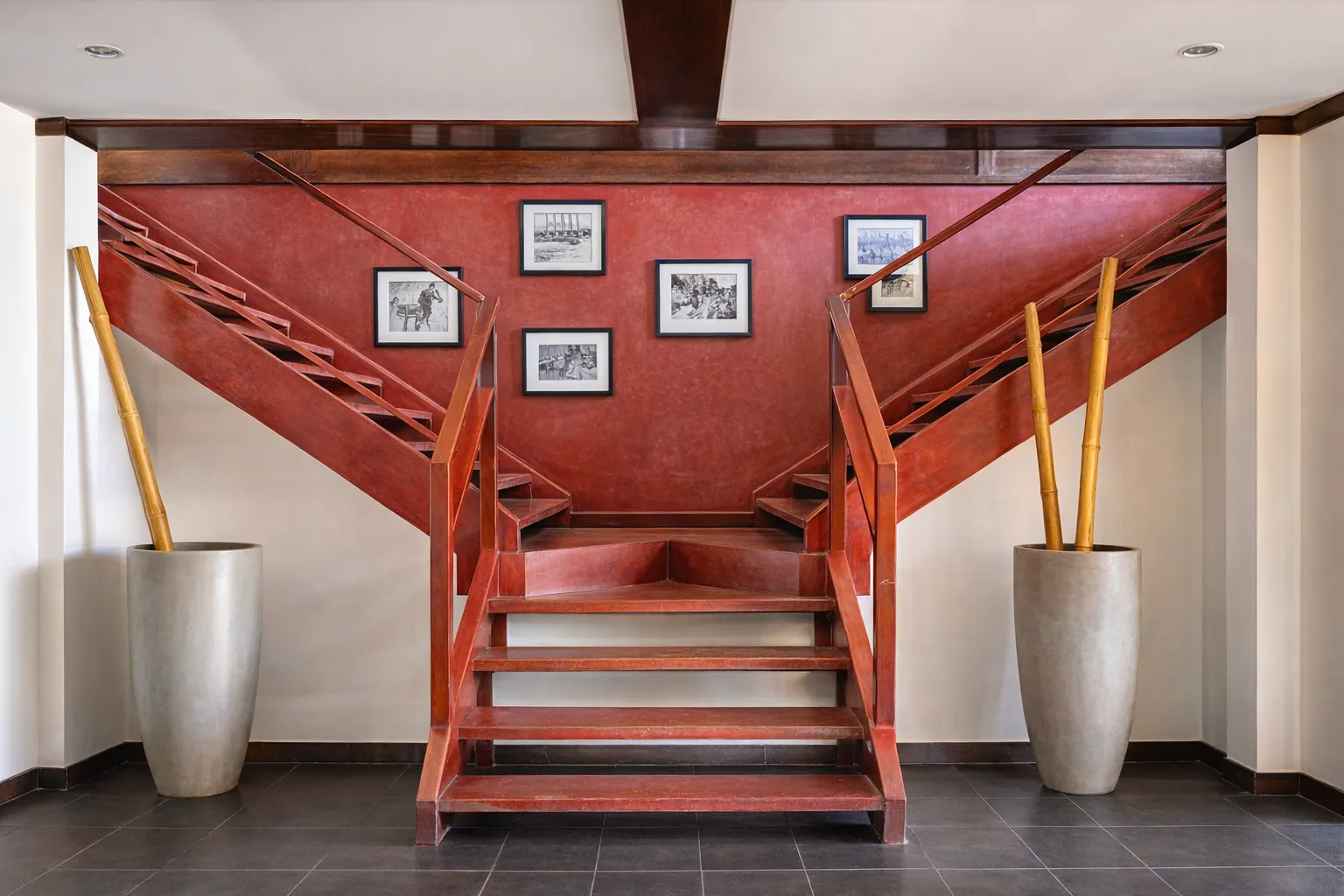Red feature staircase with Timorese art photos at Hotel Esplanada